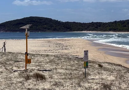 Emergency Response Beacon on Fingal Beach near Fingal Spit, with the beach and headland behind it